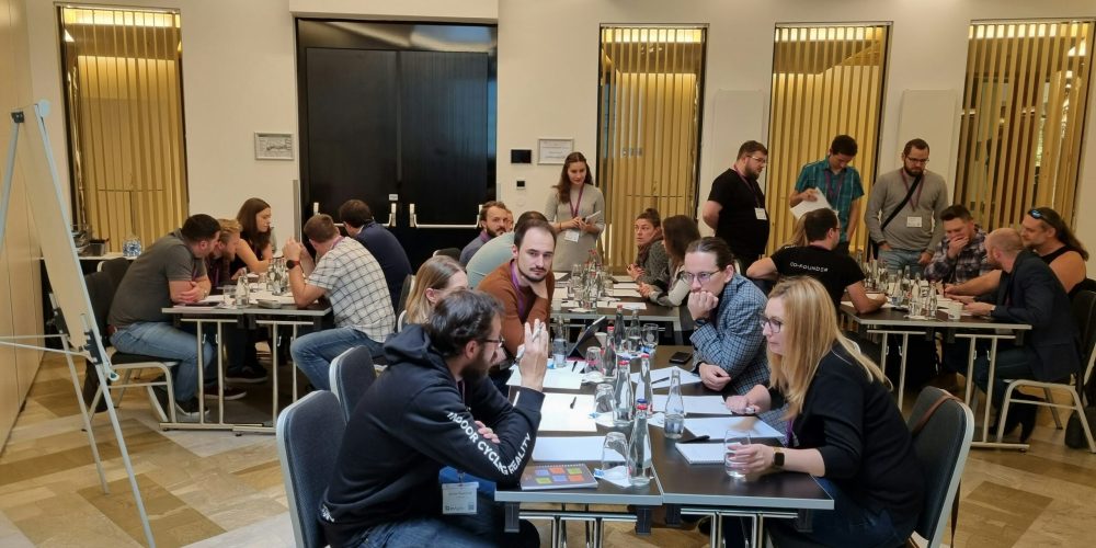 Groupe de 30 personnes collaborant lors d'un team-building gamifié avec débats collectifs intimes